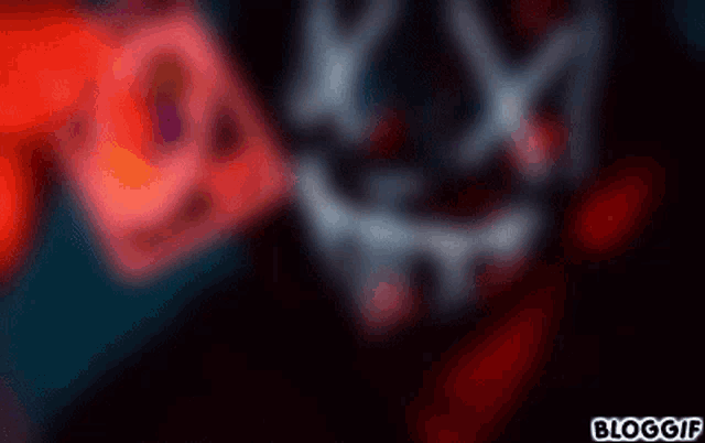 a person wearing a neon mask is holding a credit card in front of their face .