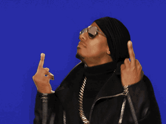 a man wearing a black hat and sunglasses shows the middle finger