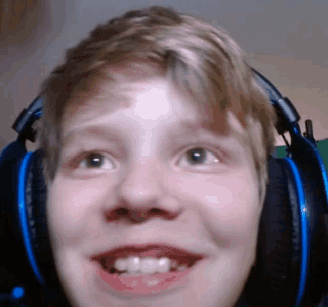 a close up of a person wearing headphones with a smile on their face