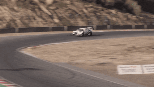a white race car is driving on a track with a sign that says castrol