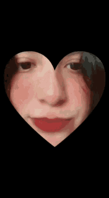 a woman 's face is behind a heart shaped frame