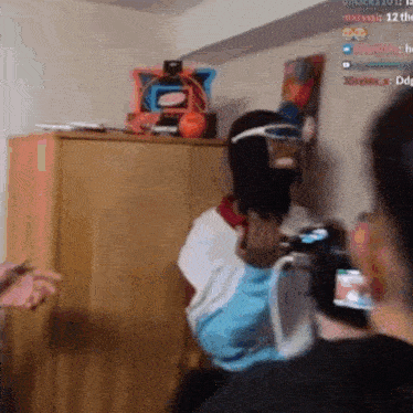 a man wearing a mask and goggles is standing in a room holding a remote control .