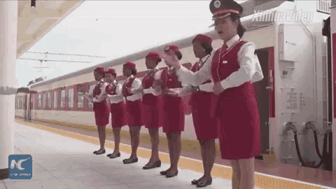 a group of women in red uniforms are standing on a platform