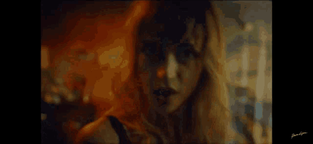 a close up of a woman 's face in a dark room with a blurred background