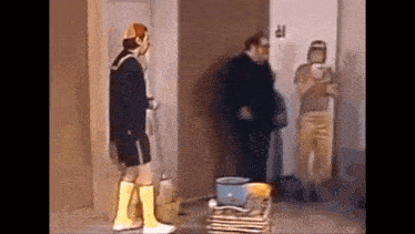 a man and a woman are standing next to each other in a room and talking .