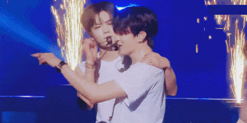 a man in a white shirt is hugging another man