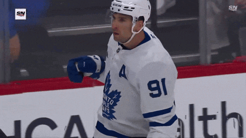 a hockey player with the number 91 on his jersey stands on the ice