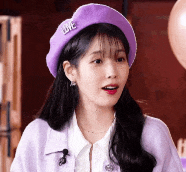 a girl wearing a purple hat with the word love on it