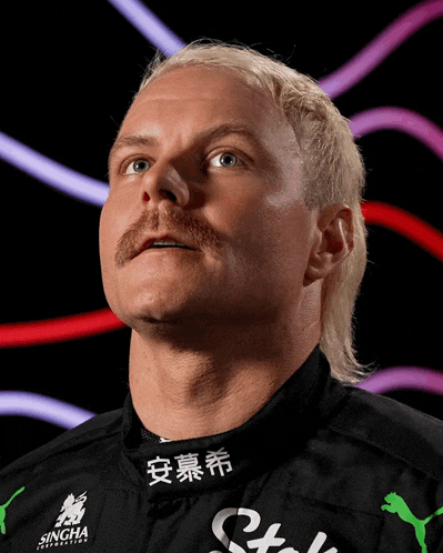 a man with blonde hair and a mustache is wearing a black shirt with singha written on it