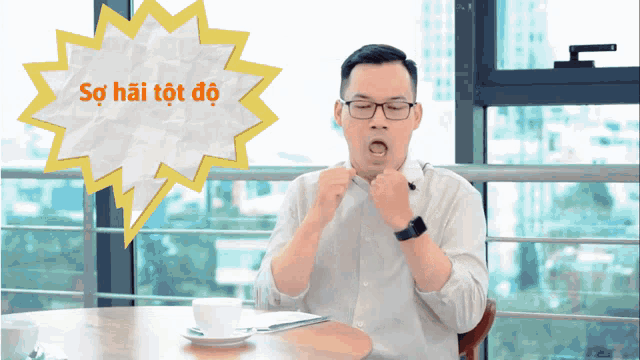 a man sitting at a table with a speech bubble that says sự hài tốt đó
