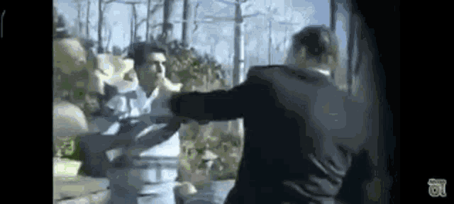 a man in a suit is standing next to another man in a park .