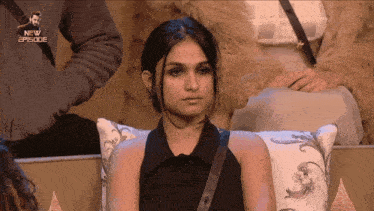 a woman sits in a chair with a new episode written on the bottom right
