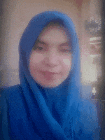 a woman wearing a blue hijab is smiling and looking at the camera