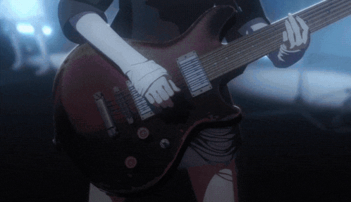 a close up of a person playing a guitar in the dark