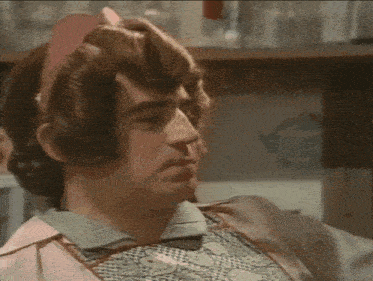 a man with a pink headband on his head is wearing an apron