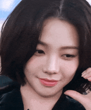 a close up of a woman 's face with a phone in her hand that says ' samsung ' on it