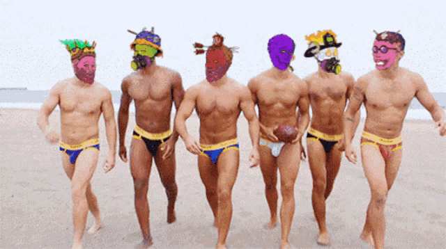 a group of men wearing underwear and masks walk on a beach