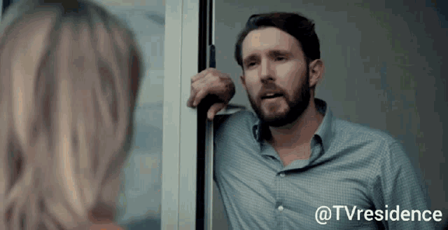 a man with a beard is standing in front of a woman with the words @tvresidence written on the bottom