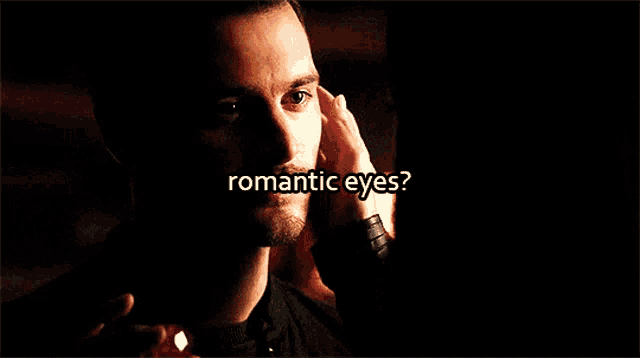 a close up of a man 's face with the words " romantic eyes " above him