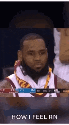 a basketball player wearing a scarf around his neck is sitting in the stands during a game .