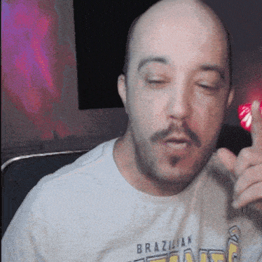 a bald man with a beard wearing a brazilian t-shirt