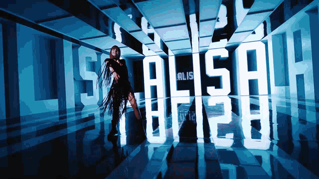 a woman in a black dress stands in front of a sign that says lisa