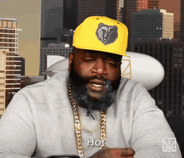a man with a beard wearing a yellow hat that says hot on it