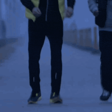 a man in a yellow vest stands next to a sign that reads 2132km