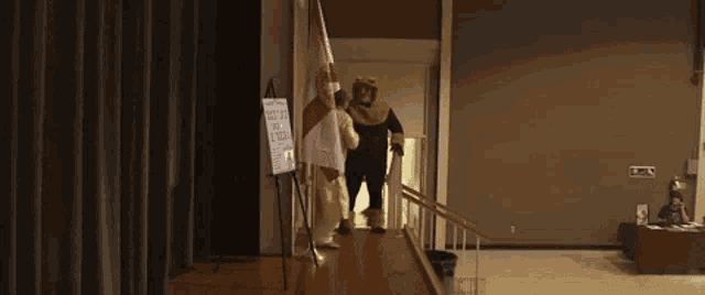 a man in a teddy bear costume is walking on a stage .