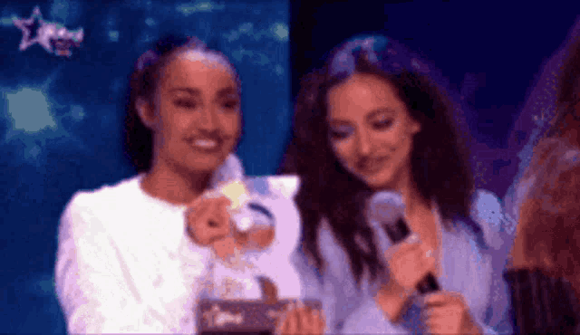 a couple of women standing next to each other with a microphone in front of them