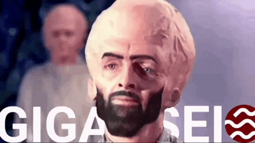 a man with a beard is standing in front of a sign that says gigaseis