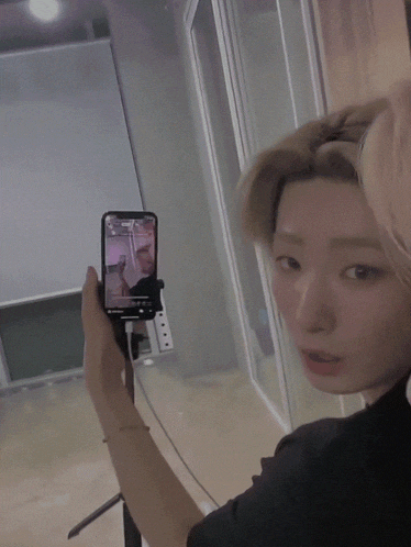 a woman taking a picture of herself with a cell phone