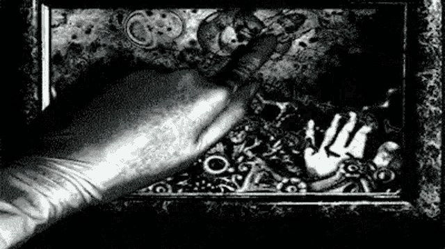 a black and white photo of a person 's hand reaching out .