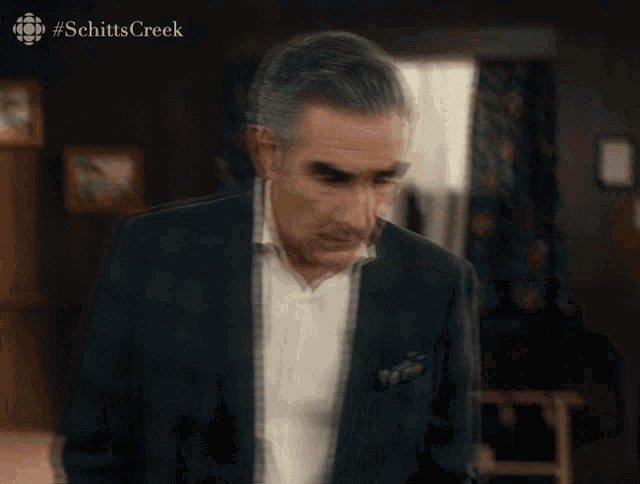 a blurred image of a man with #schittscreek written on the bottom