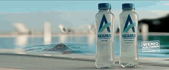 two bottles of aquarius are sitting next to each other