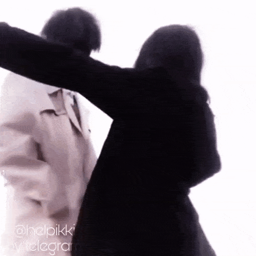 a man and a woman are standing next to each other and hugging each other .