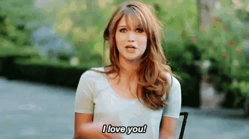a woman is sitting in a chair saying i love you .
