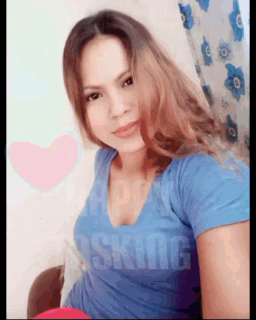 a woman in a blue shirt is taking a selfie with the word asking in the corner
