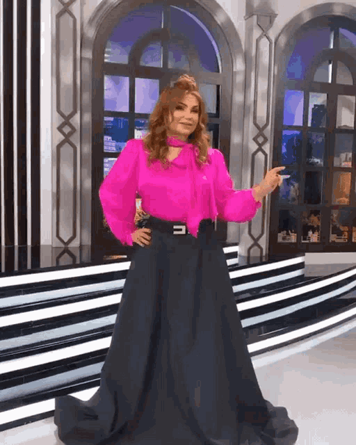 a woman in a pink blouse and black skirt