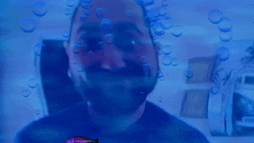 a man with a beard is surrounded by bubbles and fish