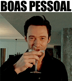 a man holding a glass of wine with the words boas pessoal behind him