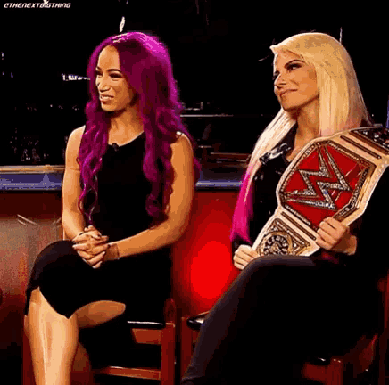 two women with purple hair are sitting next to each other .