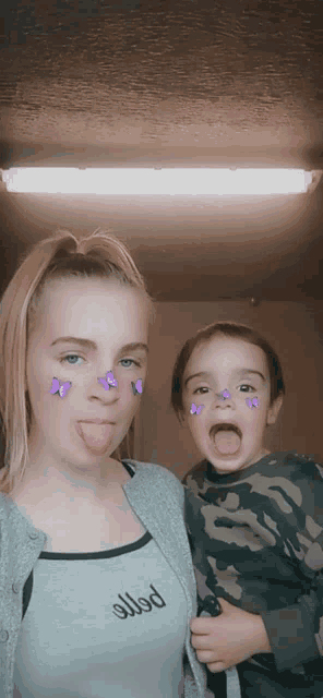 a woman with purple butterflies on her face holds a child