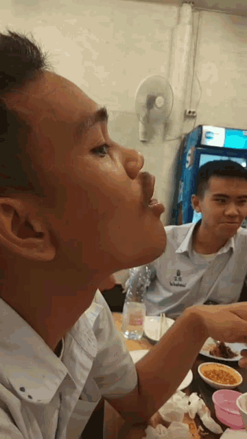 a man sitting at a table with a bottle of coca cola