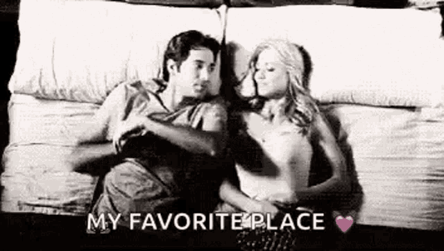 a man and a woman are laying on a bed hugging and kissing .