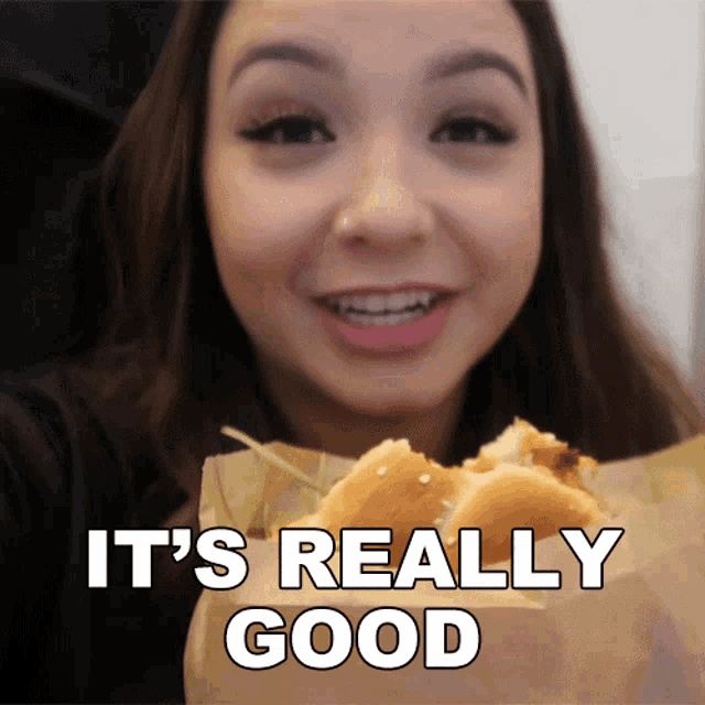 a woman eating a sandwich with the words " it 's really good " written below her