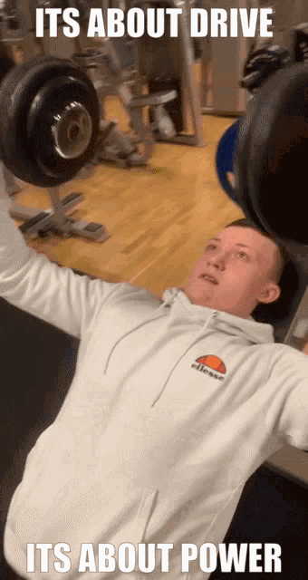 a man in an ellesse sweatshirt is lifting weights