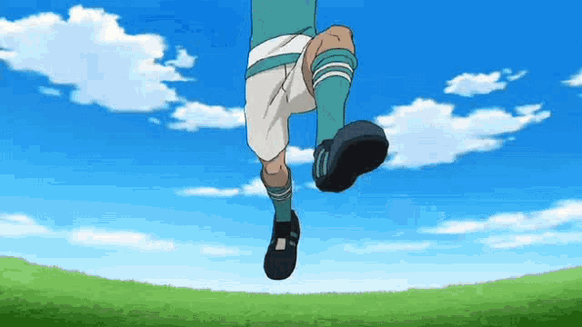 a soccer player is jumping in the air while kicking a ball .