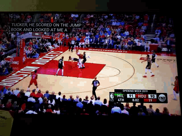 a tv screen shows a basketball game between the houston rockets and milwaukee bucks