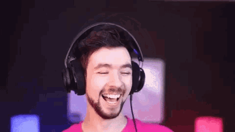 a man wearing headphones is laughing and smiling .